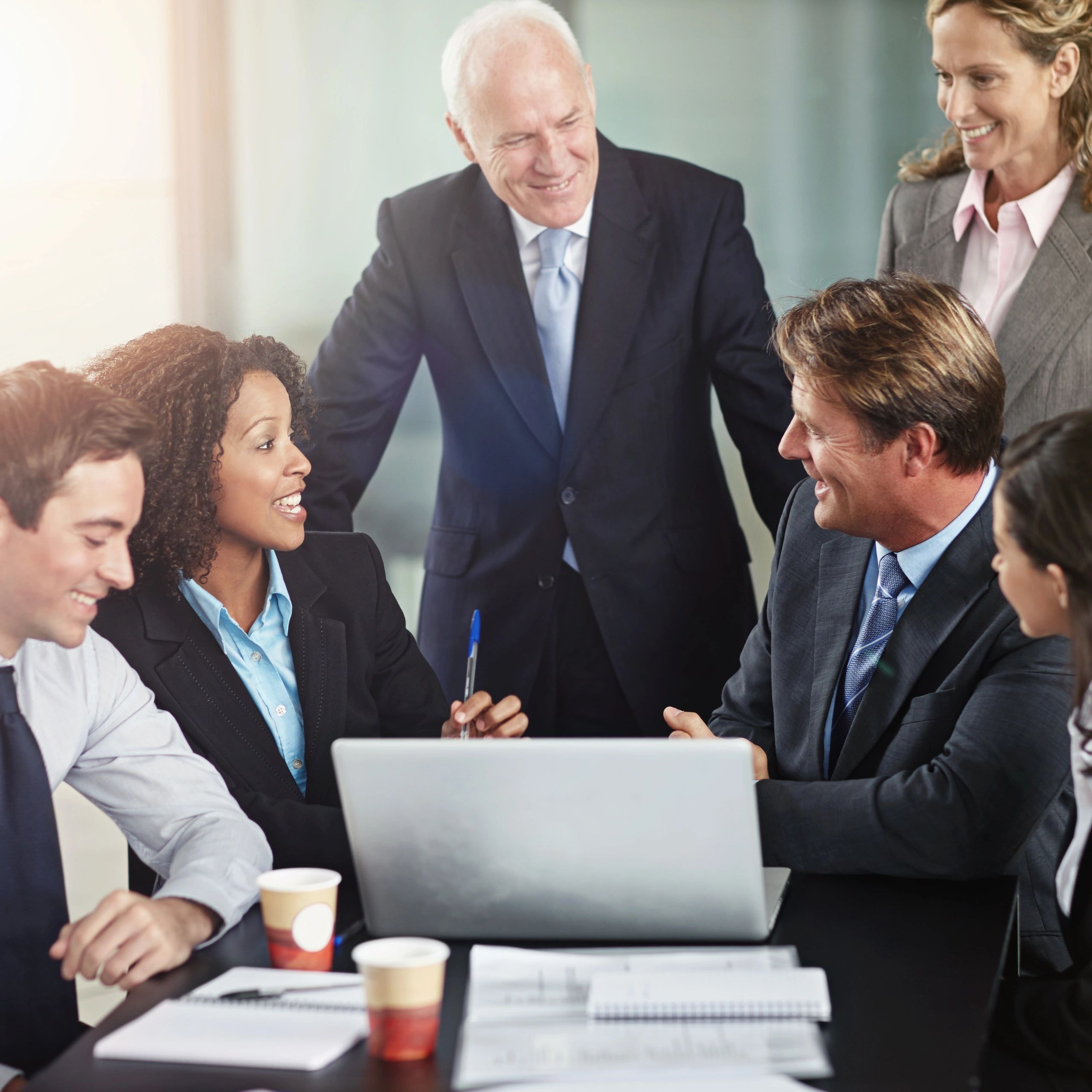 Diverse business professionals collaborating around a laptop